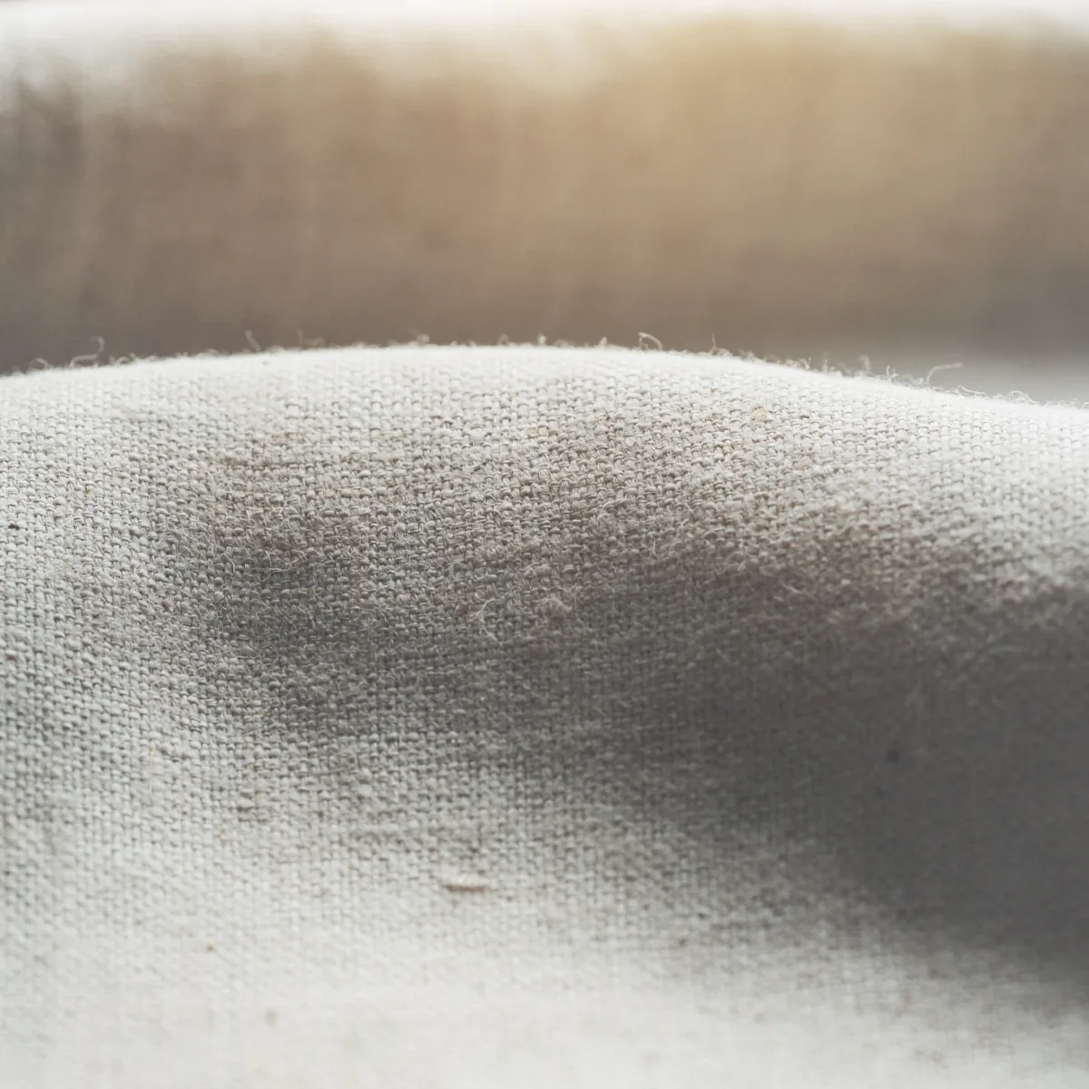 A close view of coarse woven linen in low daylight.